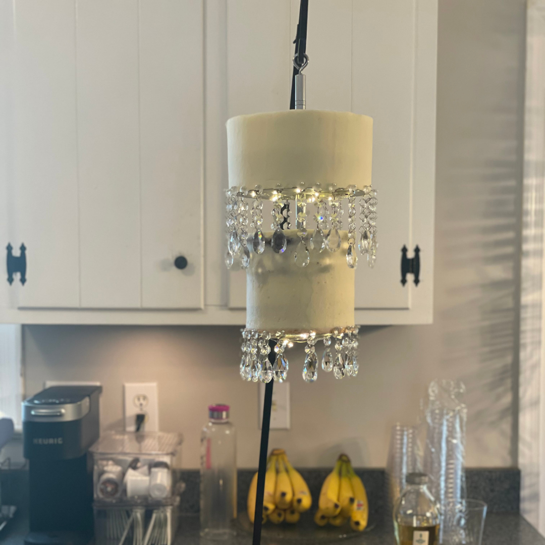 A unique chandelier-style cake suspended with crystal strands and glowing lights.