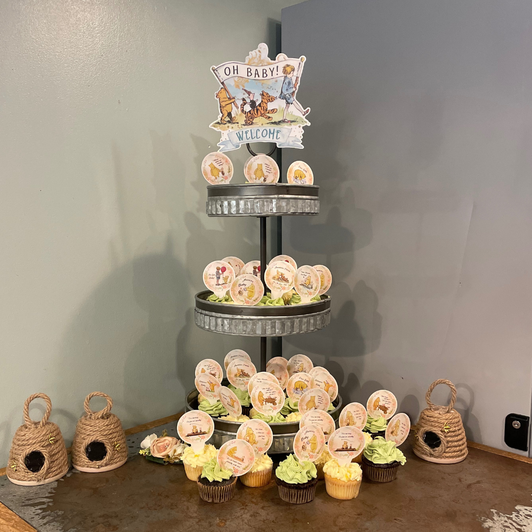 Chocolate and Vanilla cupcakes decorated with pastel-colored icing with Winnie the Pooh toppers