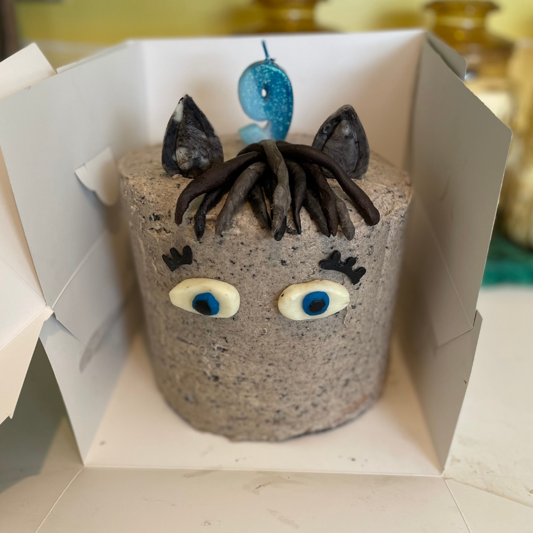 Cookies and cream cake decorated like a horse with blue eyes, ears, and mane.