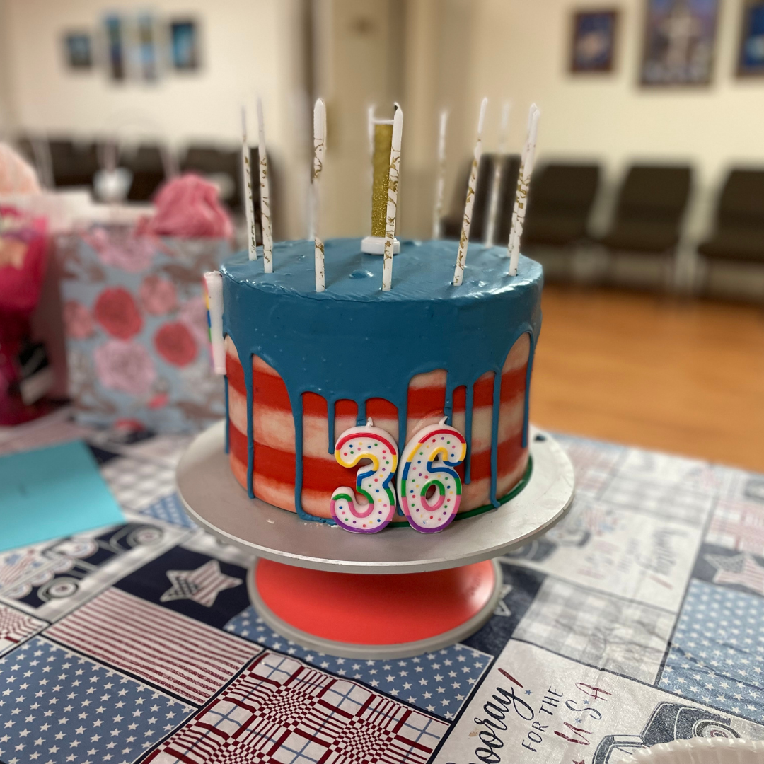 Red, white, and blue striped birthday cake with number 36 candles.