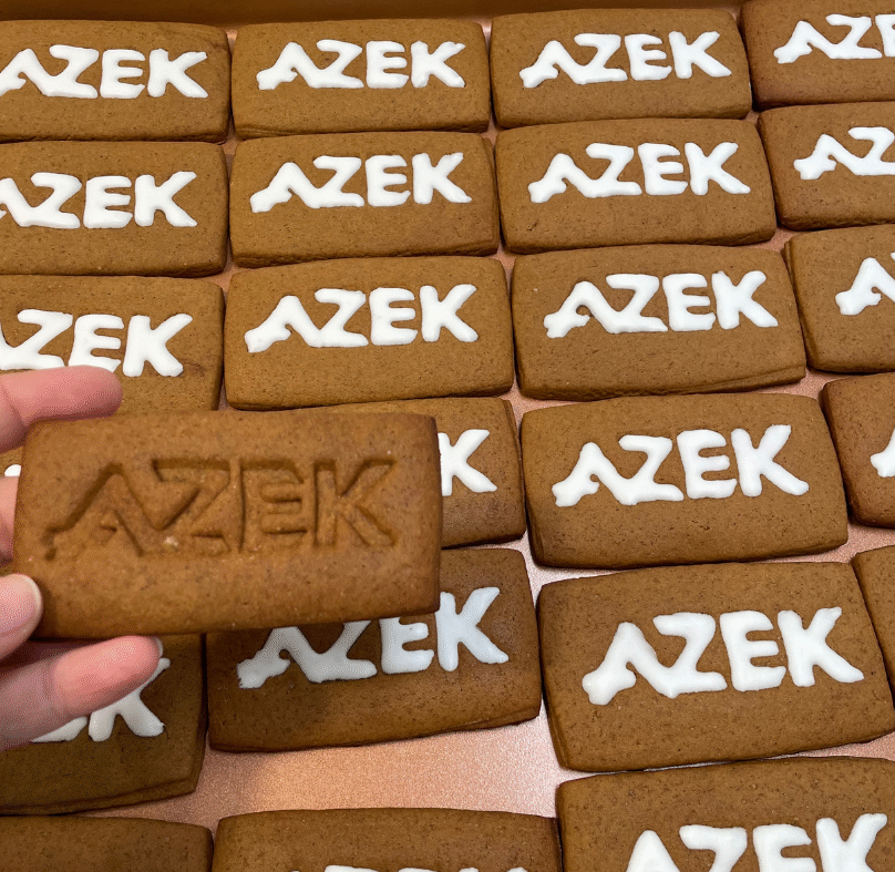 Royal icing cookies, stamped and filled with royal icing in a company logo.