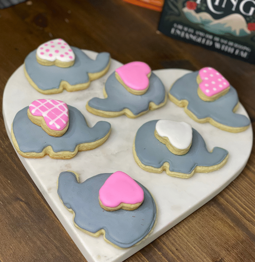 Royal icing cookies shaped like elephants, double-stacked with tiny heart cookies for ears.